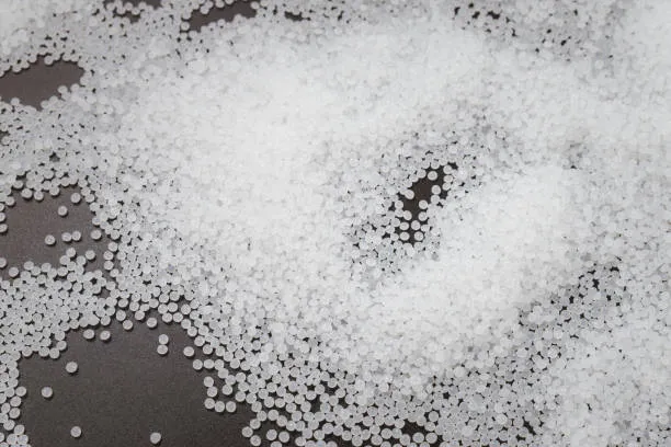 Food grade calcium carbonate granules displayed on a black tray.